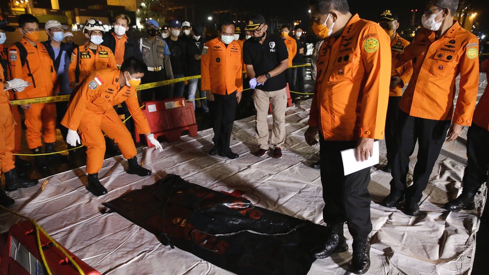 Indonezija, avionske nesreće: Locirane crne kutije, pronađeni delovi aviona i ljudskih tela 3 Indonesian search and rescue officers inspect a bag with wreckage believed to be of the missing Sriwijaya Air plane, at Tanjung Priok port in Jakarta, Indonesia, 10 January 2021