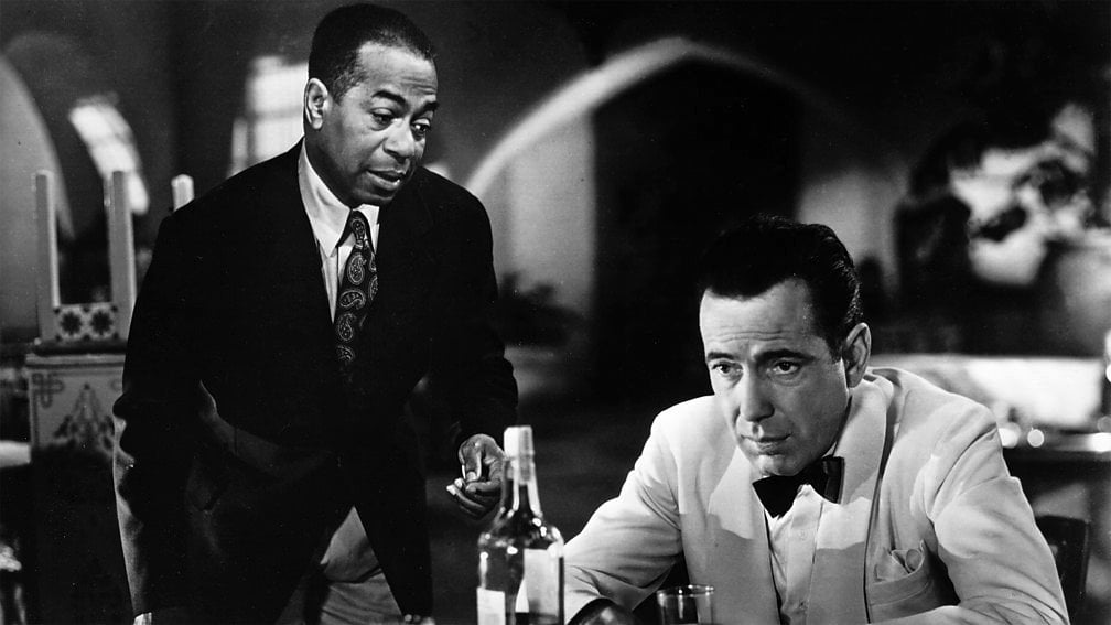 Hemfri Bogart kao Rik Blejn utapa tugu u čaši sa Semom (Duli Vilson)