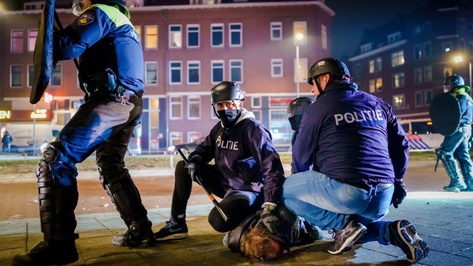 Korona virus, protesti i Holandija: Najgori neredi u poslednjih nekoliko decenija, uhapšeno 150 ljudi 1 Dutch policemen arrest a man during clashes with a large group of young people on Beijerlandselaan in Rotterdam