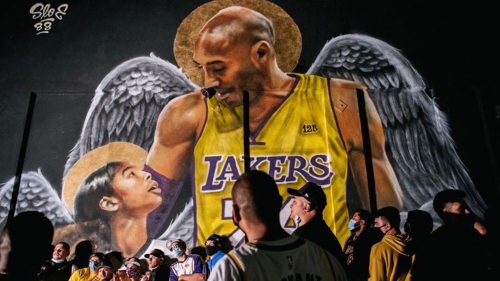 Lakers fans celebrate near a mural of Kobe Bryant and his daughter Gianna