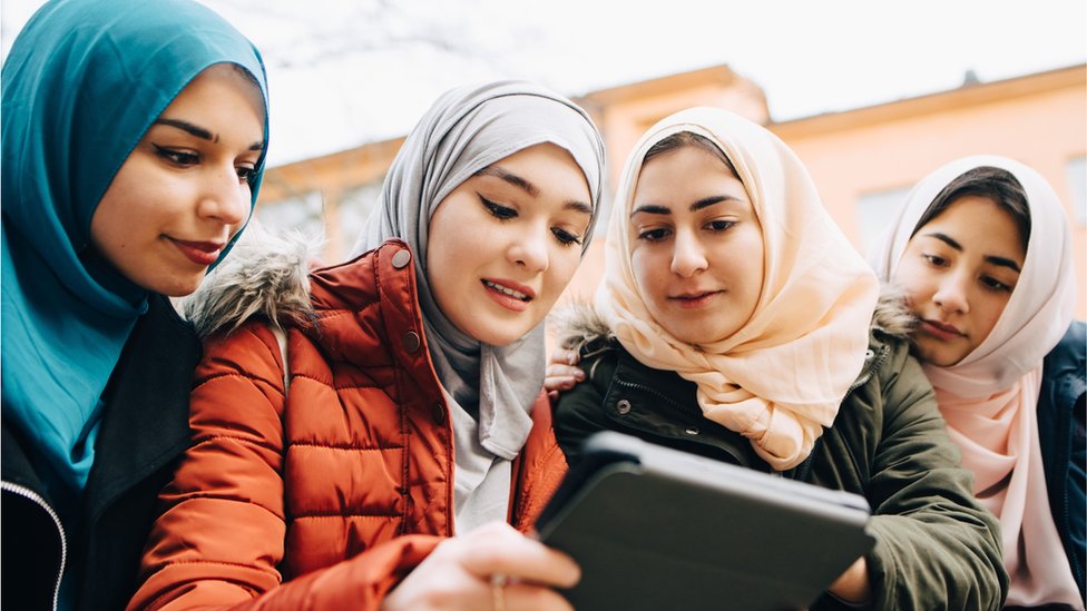 Young Muslim women looking into an iPad