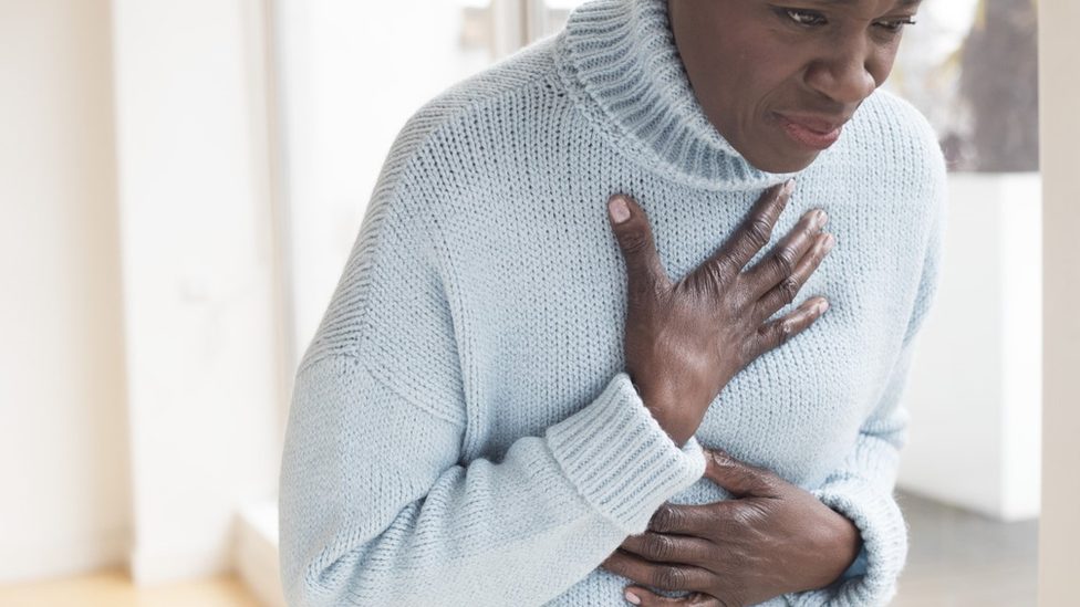 A woman holding on to her chest in pain