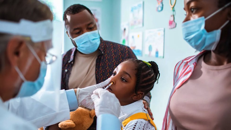 Korona virus i vakcinacija: Možete li da prenesete Kovid-19 ako ste vakcinisani 2 A girl being given nasal immunisation, her parents are by her side