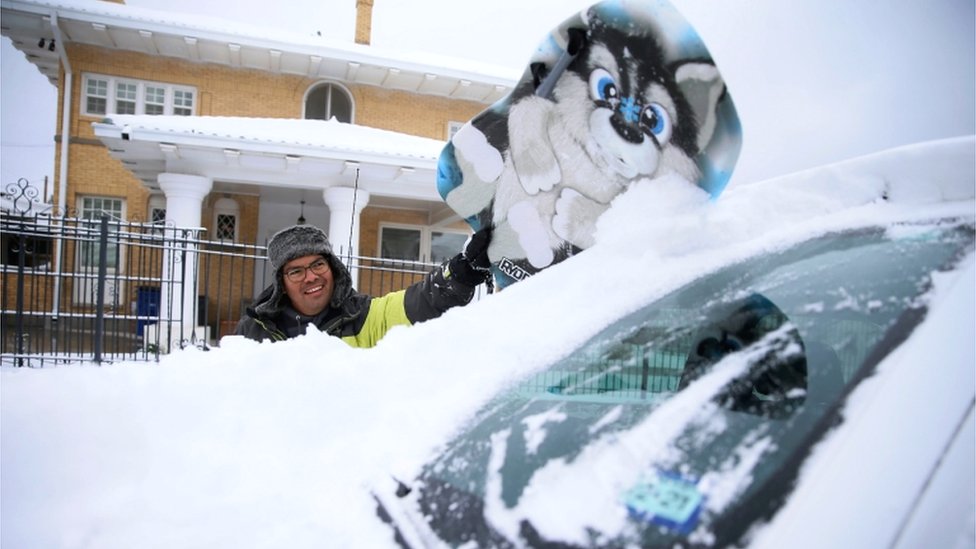 Vremenske nepogode i Amerika: Snežna oluja okovala SAD - 21 čovek preminuo, širom zemlje restrikcije struje 3 Francisco Sanchez wipes snow off his car with a boogie board before going out sledding with his kids on Valentine's Day at Memorial Park in El Paso, Texas, US, 14 February 2021