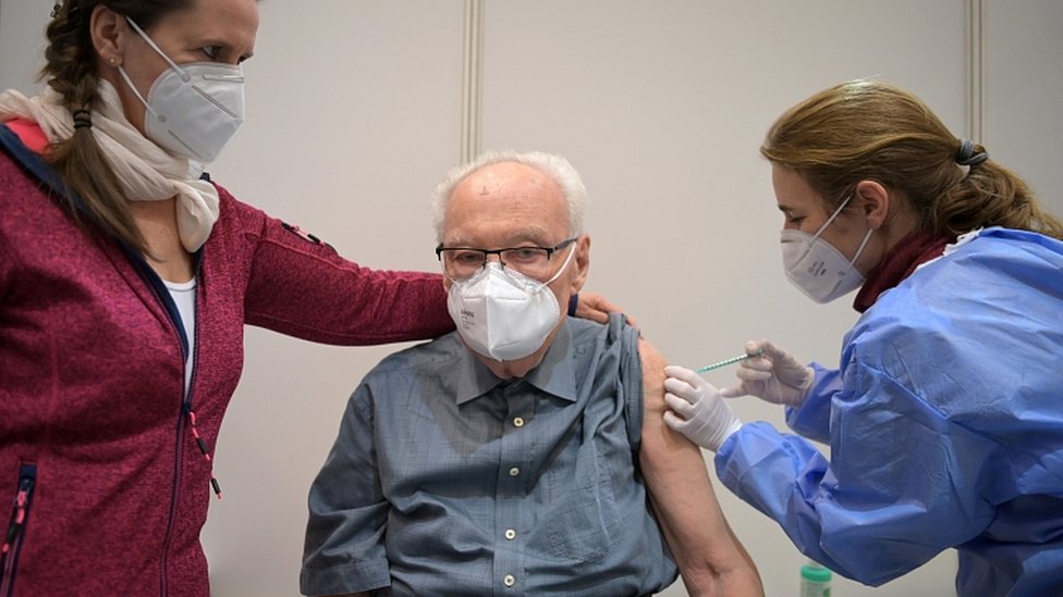 Korona virus: Stiže novi kontigent ruskih vakcina u Srbiju, u Britaniji imunizovano 20 miliona ljudi 1 Werner Boestfleisch, 86, receives a dose of the Pfizer-BioNTech vaccine at the Metropolis-Halle vaccination centre in Potsdam, Germany, January 5, 2021