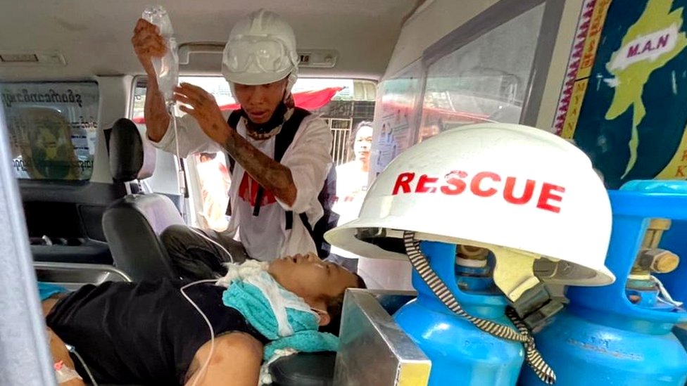 Emergency workers treat an injured man in Yangon's Hledan township