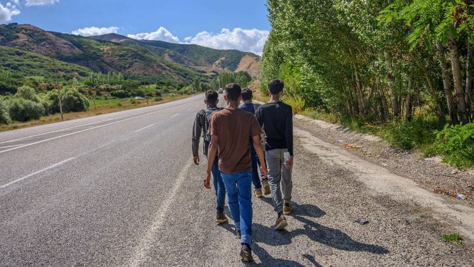 Migrants walking along the road in northern Iran towards Turkish border