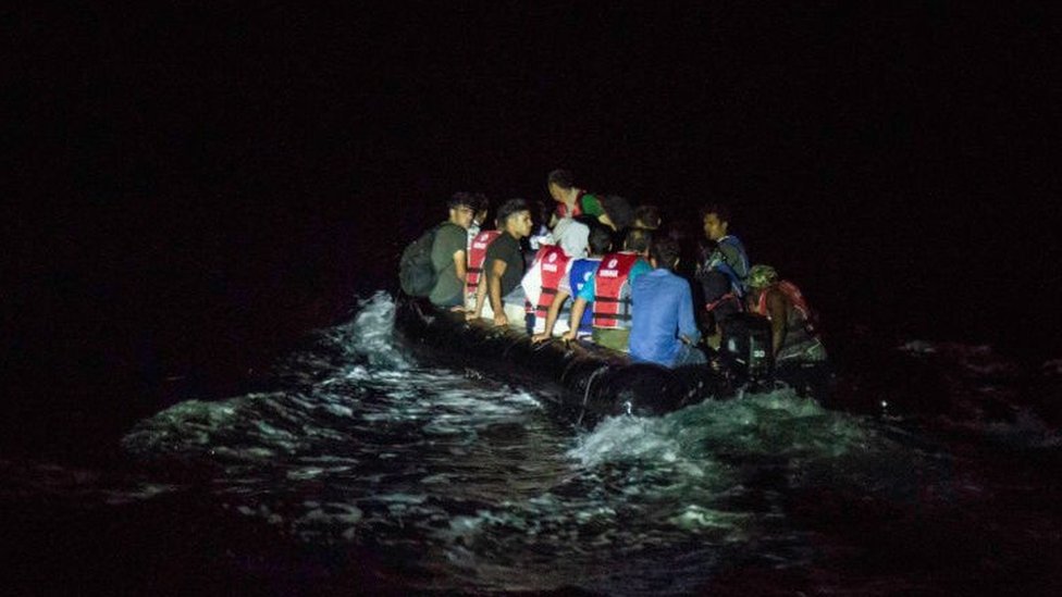 A rubber dinghy full of migrants crossing to the Greek island of Lesvos at night