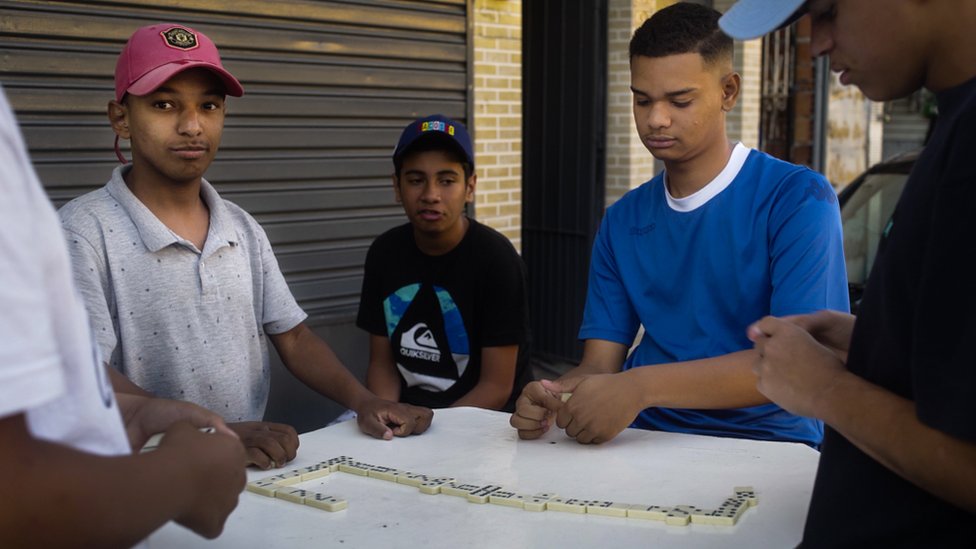 Teenagers move their domino game to the street during the coronavirus pandemic