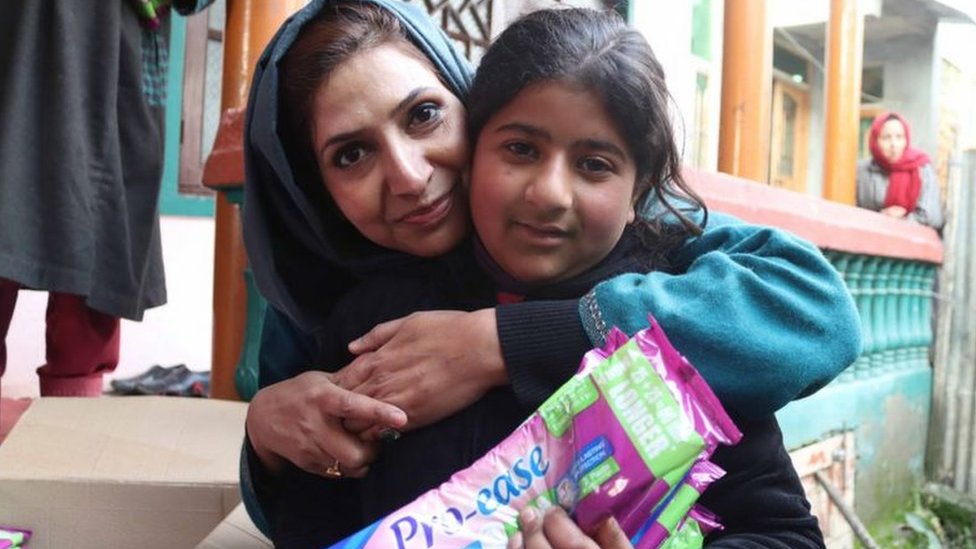 Irfana Zargar hugging a teenager who just got sanitary pads from her