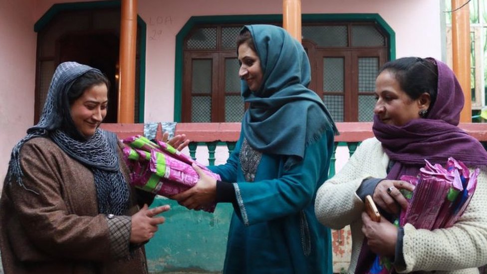 Irfana giving pads to a Kashmiri woman