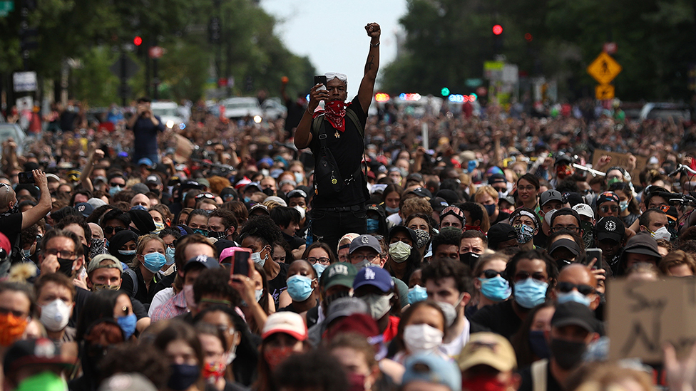 A man holds up his fist while hundreds of demonstrators march to protest against police brutality and the death of George Floyd, on June 2, 2020 in Washington, DC.