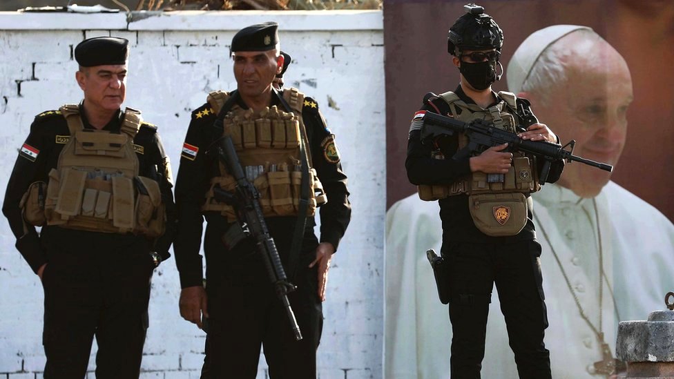 Security keep watch as a motorcade carrying Pope Francis arrives in Baghdad, Iraq, 5 March 2021