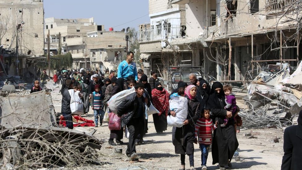 Sukobi i Bliski istok: Zašto rat u Siriji rat traje 10 godina 8 Syrian civilians leave the rebel-held town of Jisreen in the southern Eastern Ghouta during a government offensive (17 March 2018)