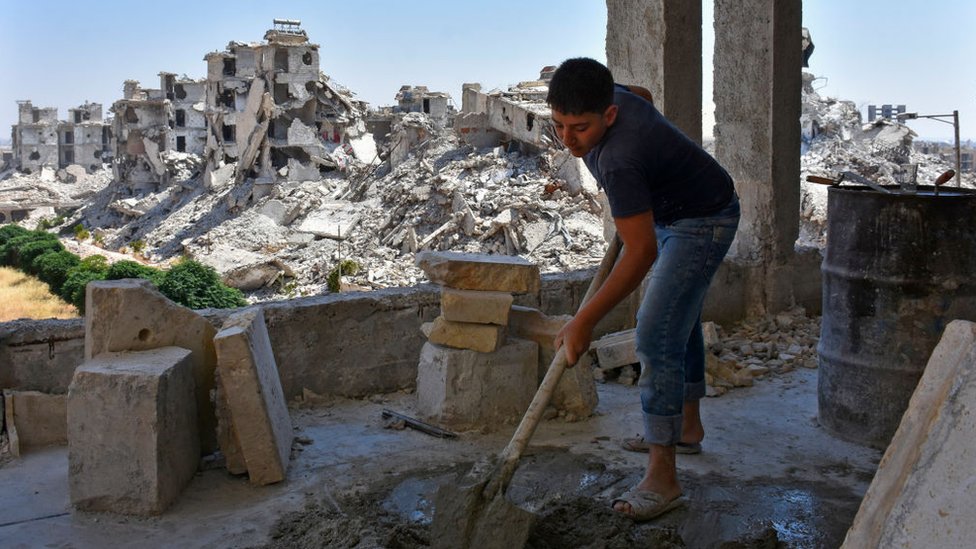 Sukobi i Bliski istok: Zašto rat u Siriji rat traje 10 godina 12 A Syrian labourer works as homes are rebuilt in Zahraa area of Aleppo (6 July 2020)