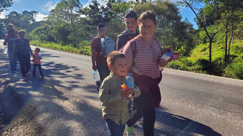 Migrants walk along the road