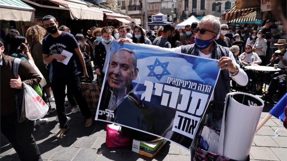 Man holds up pro-Netanyahu poster in Jerusalem (21/03/21)