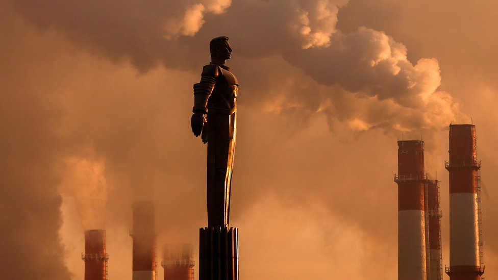 Steam rising from chimneys plant near a monument of Yuri Gagarin, during sunset in Moscow