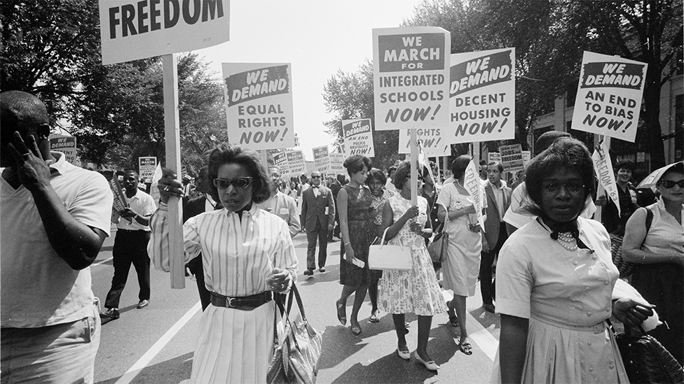 Civil rights march on Washington, DC, USA. Procession of African Americans carrying placards demanding equal rights, integrated schools, decent housing, and an end to bias