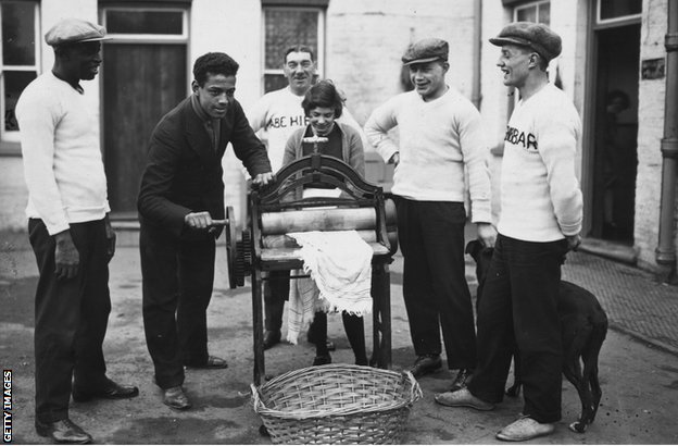 Spot, boks i rasizam: Len Džonson - borac sa 93 pobede koji nikada nije mogao da postane šampion Velike Britanije 4 31st December 1926: Len Johnson British light-heavyweight boxing champion, helps with the mangling, his father is on the left. (Photo by Brooke/Topical Press Agency/Getty Images)