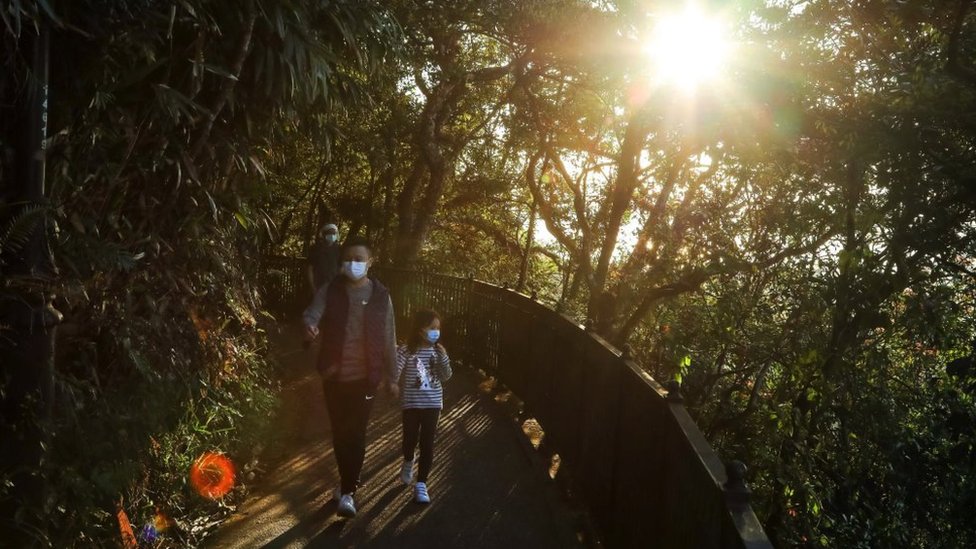 A family walking in a park path in Hong Kong