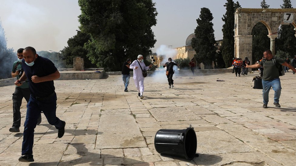 Palestinians run away after Israeli police fire stun grenades during clashes around the al-Aqsa mosque, in occupied East Jerusalem (10 May 2021)