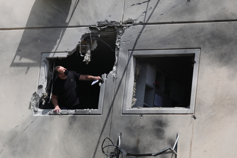 A man inspects damage on a building in the city of Ashkelon, Israel