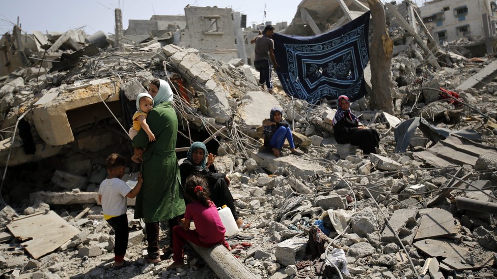 Members of the al-Kafarna family inspect the rubble of their destroyed house in Beit Hanoun, northern Gaza, on 1 August 2014