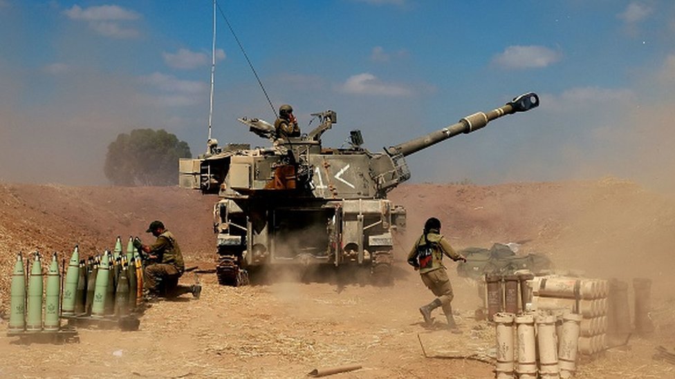Israeli soldiers fire towards the Gaza Strip on 13 May