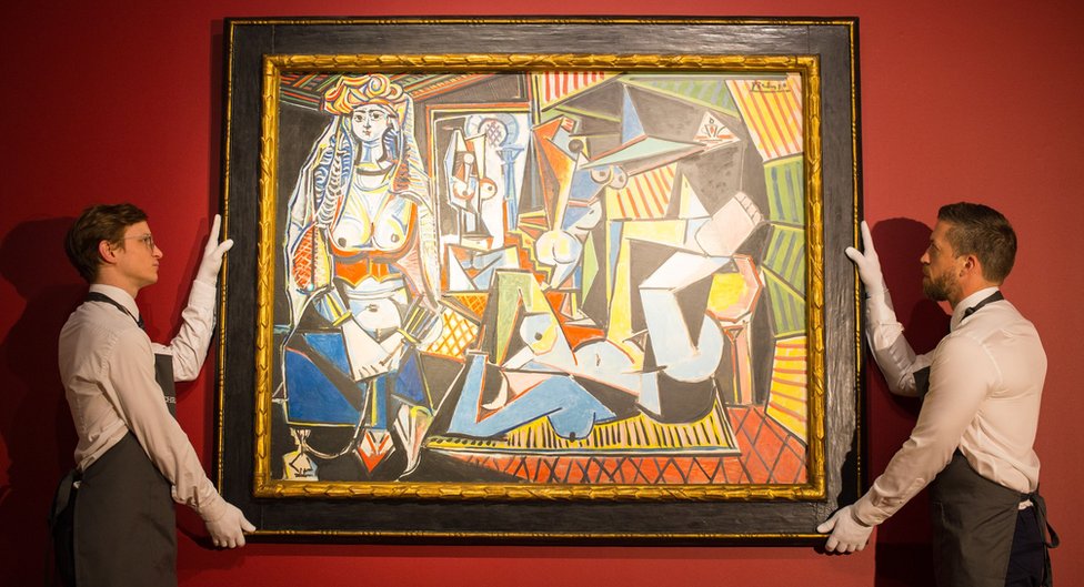 Gallery staff at Christie"s London showroom hang Les femmes d'Alger (The Women of Algiers) by Pablo Picasso in 2015