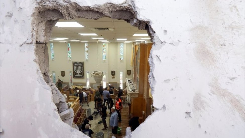 People clean inside a synagogue damaged by a rocket, as Israeli-Palestinian cross-border violence continues, in Ashkelon, southern Israel May 16, 2021