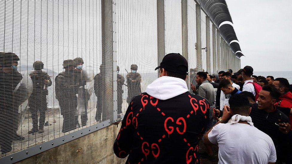 Spanish troops and Moroccan migrants at Ceuta border fence, 18 May 21