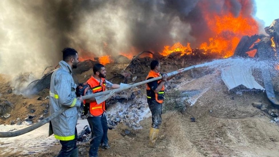 Palestinian firefighters put out a fire at building hit by Israeli strikes in southern Gaza