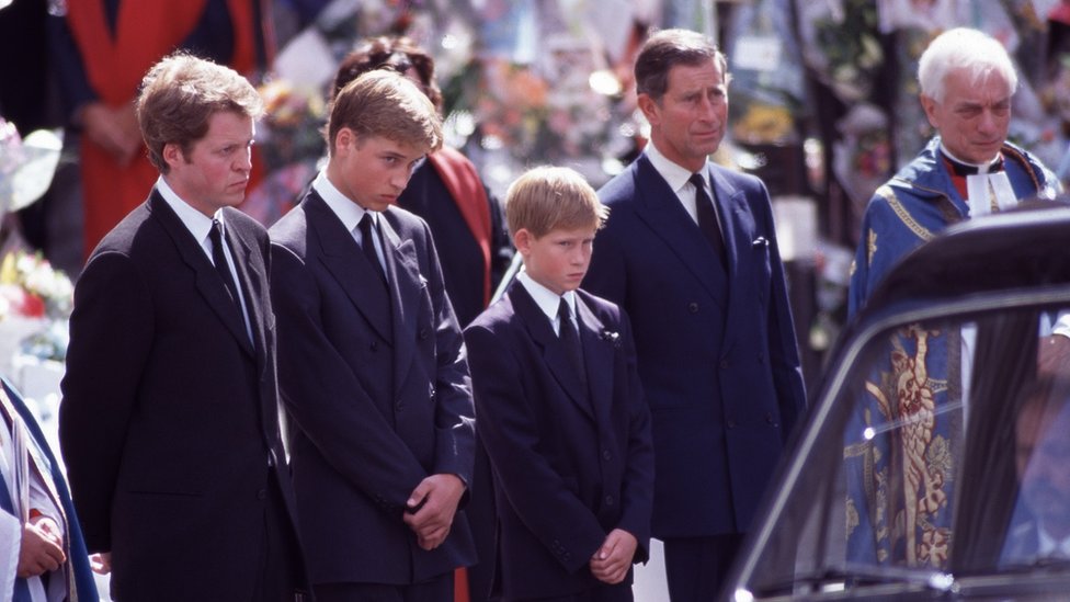 Prince Harry and his family standing beside his mum's hearse at her funeral