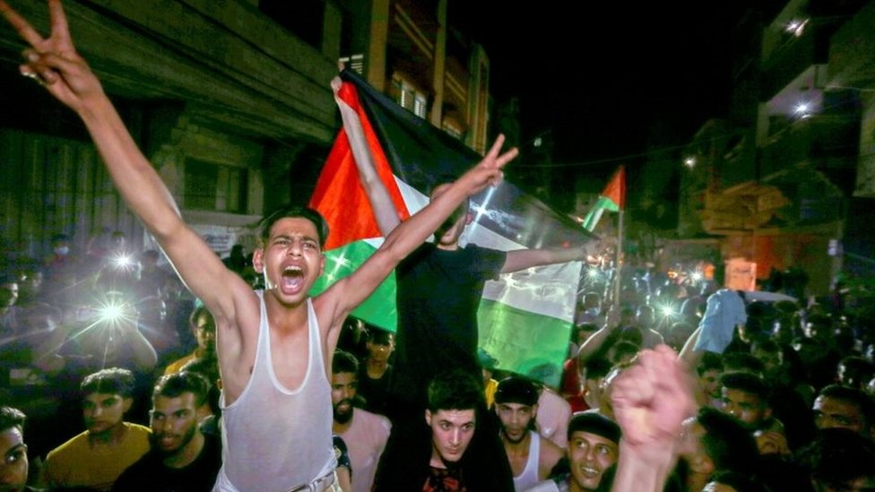 Palestinians celebrate in the streets following a ceasefire, in the southern Gaza Strip