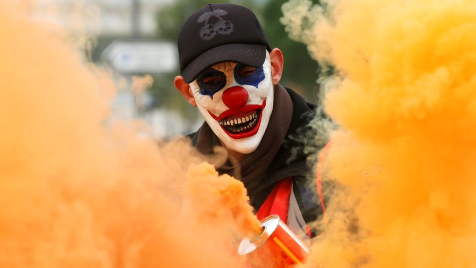 A protester wearing a mask is seen amongst smoke