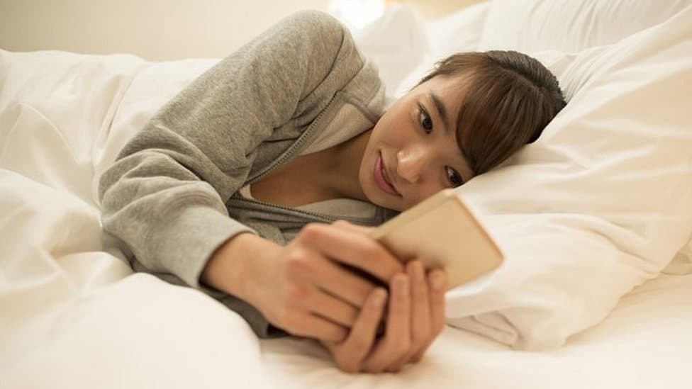 Woman using mobile phone at home