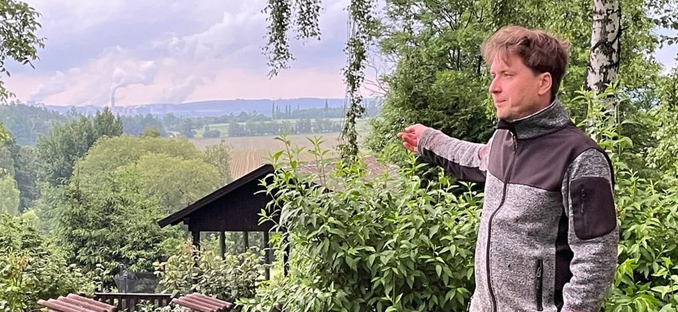 Milan Starec pokazuje na termoelektranu Turov preko granice
