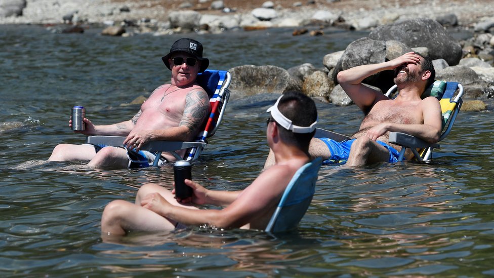 Kanada, vrućine i toplotni talas: Desetine stradalih, vatra progutala malo mesto 5 Beachgoers sit in the water at Alouette Lake to cool off during the scorching weather of a heatwave in Maple Ridge, British Columbia