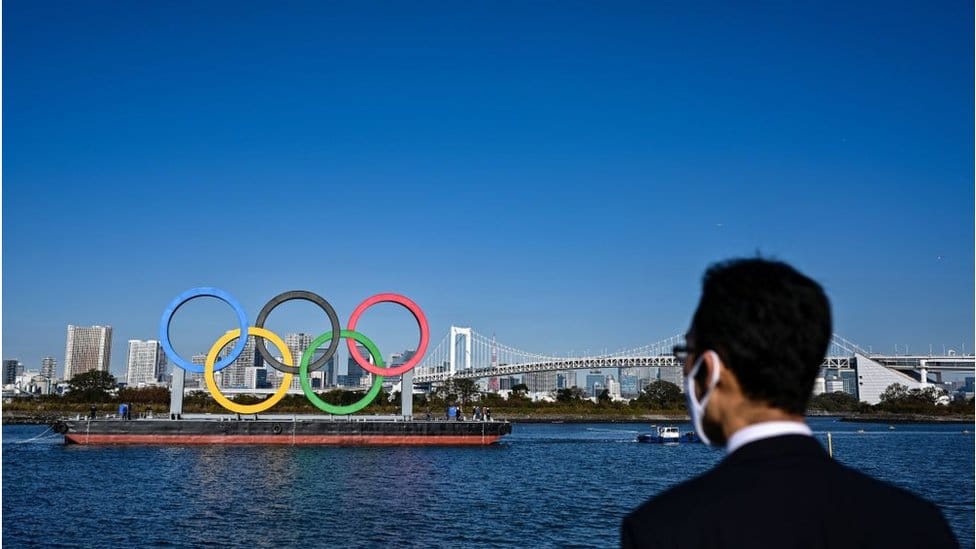 Tokio 2020: Kako je korona virus promenio Olimpijske igre i zašto neće biti publike 1 Man looking at Olympic rings