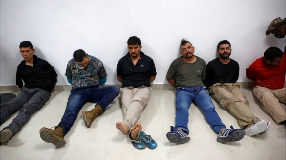 Ubistvo predsednika Haitija: „Pokosio ga je rafal, ni reč nije stigao da izusti" 1 Men accused of the president's assassination sit against a wall