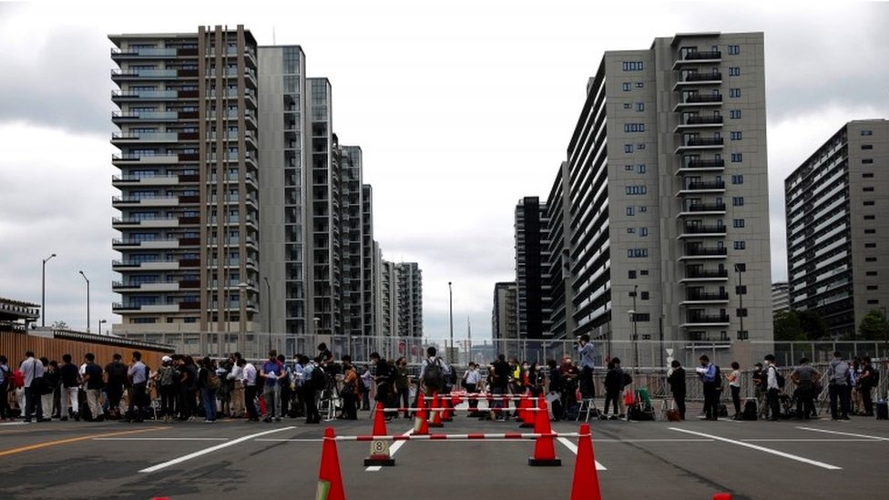 Korona virus i Olimpijske igre: Mogu li vlasti u Japanu da spreče da manifestacija postane „događaj super širenja zaraze“ 3 Fences and people queue outside the Olympic Village