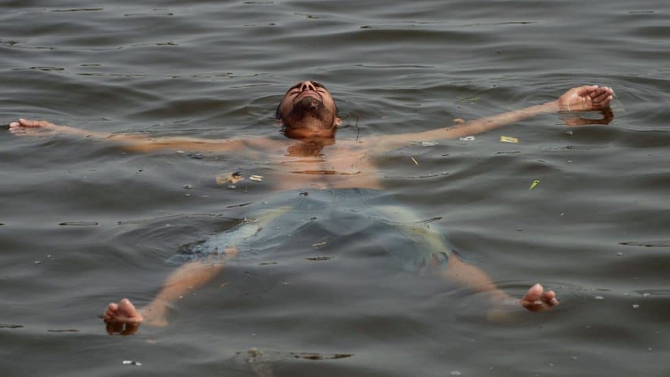 A Pakistani youth cools off in the sea during a heatwave in Karachi