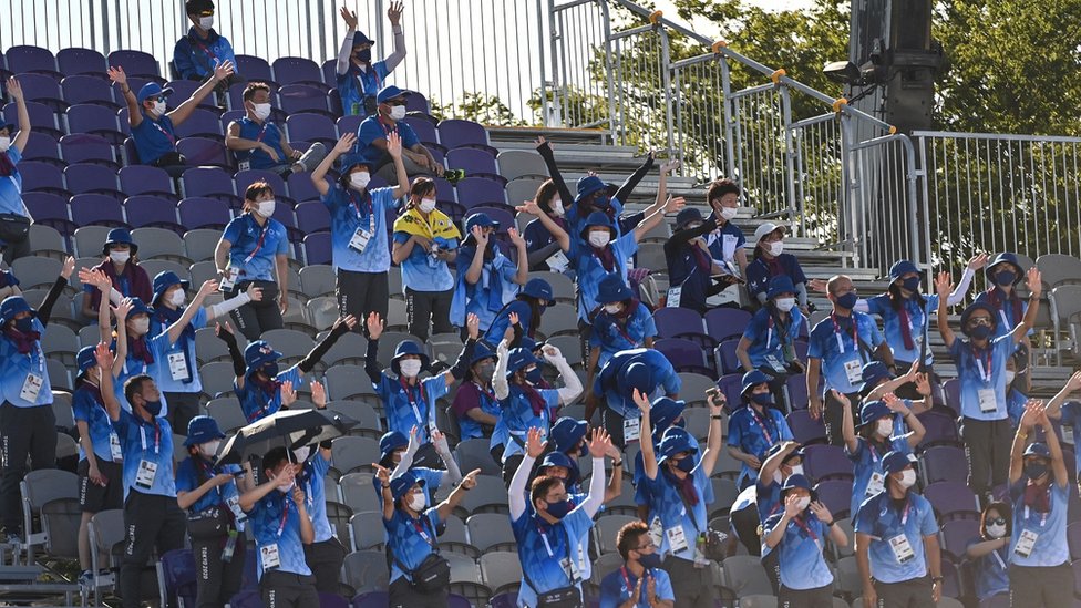 Olimpijske igre u Tokiju: Volonteri na takmičenju drugačijem od svih do sada 4 Dozens of volunteers at an Olympic event clapping.