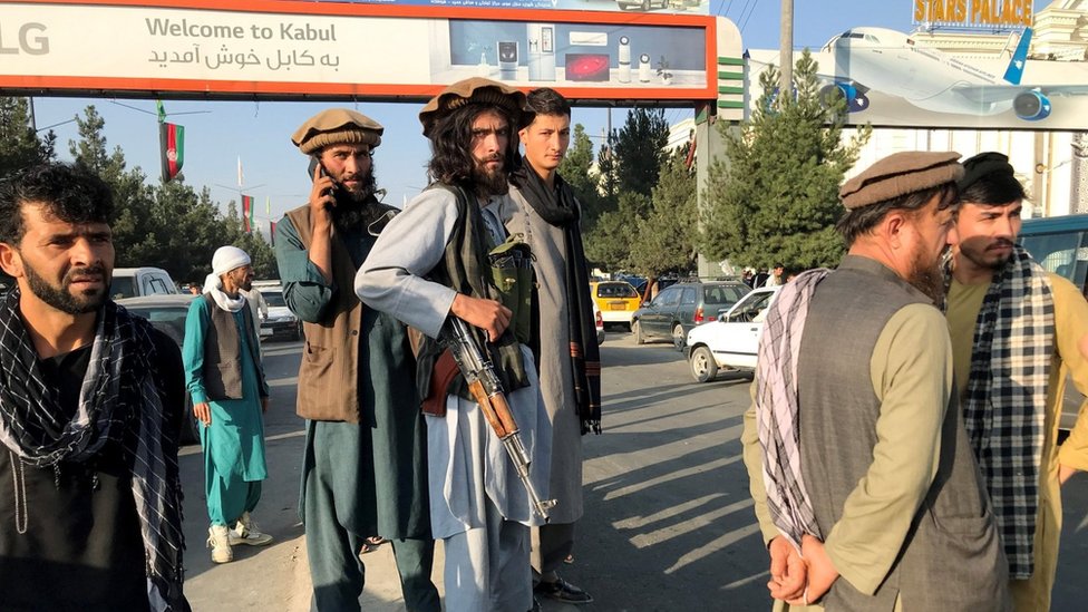 A Taliban fighter stands outside Hamid Karzai International Airport in Kabul, Afghanistan, August 16, 2021