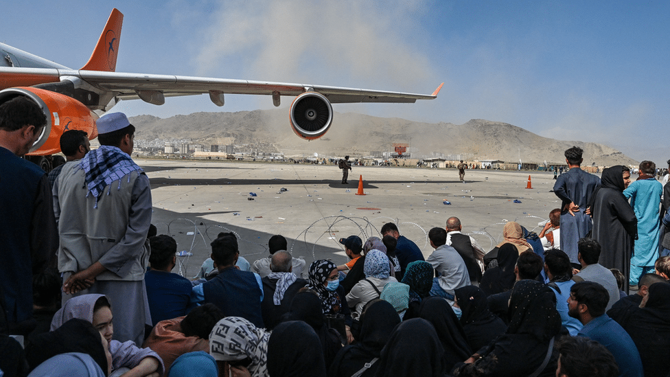 Rat i Avganistan: Državljani Srbije na aerodromu u Kabulu, fotografija koja svedoči o muci Avganistanaca 4 Afghan people sit as they wait to leave the Kabul airport in Kabul on August 16, 2021