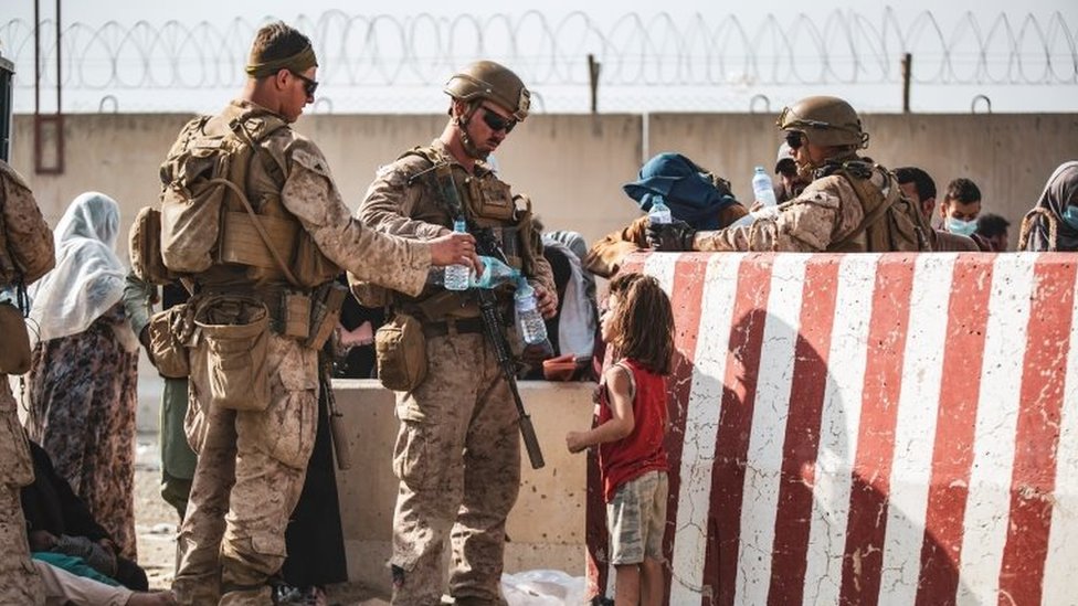 Avganistan: Direktor CIA pregovarao sa talibanima, Kina kritkuje Ameriku zbog povlačenja 2 U.S. Marine hand out water during an evacuation at Hamid Karzai International Airport