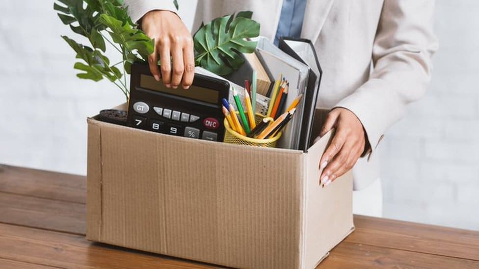 A person gathering her belongings at the office