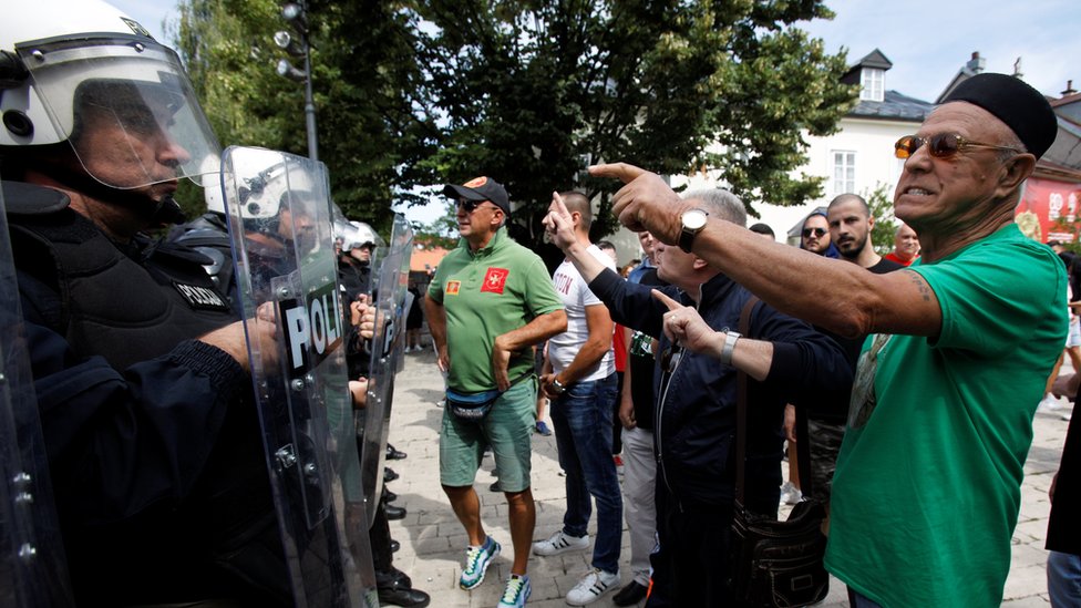 Demonstrators shout at riot police during a protest against enthronement of Bishop Joanikije in Cetinje