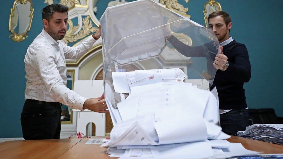 Members of a local election commission empty a ballot box after polls closed during a three-day long parliamentary election, at a polling station inside Kazansky railway terminal in Moscow, Russia September 19, 2021.